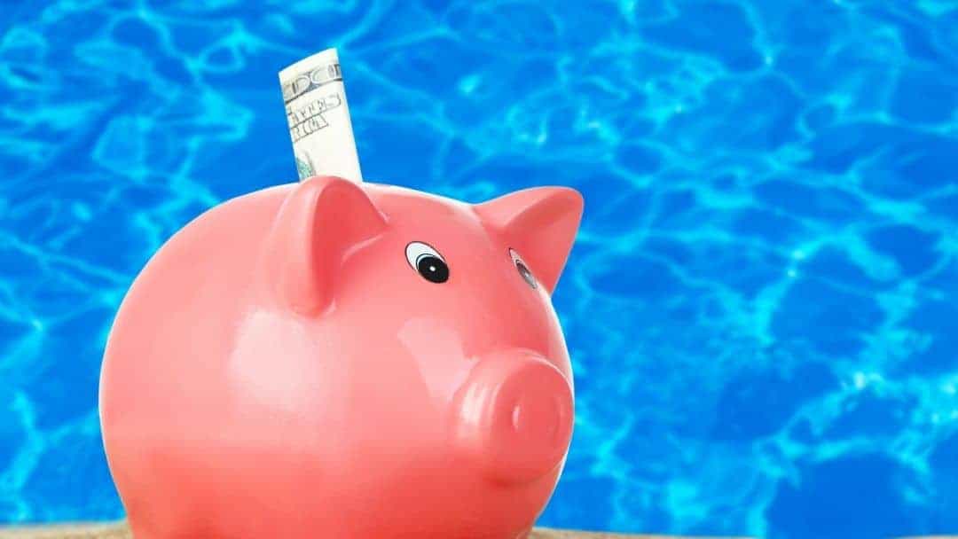 Image of a piggy bank in front of blue waters representing the next section on swimming pool financing.