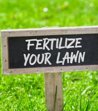 A yard sign that reads 'Fertilize your Lawn'